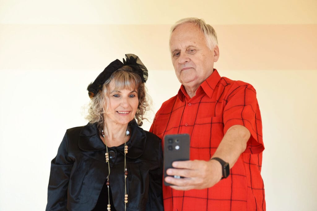 Starsza para mężczyzna i kobieta używają telefonu komórkowego.